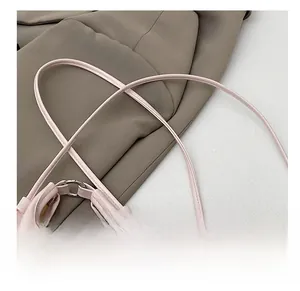 Dettaglio della borsa in pelle rosa con anello in metallo argento e sottile tracolla