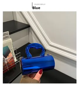 Close-up of metallic blue cylindrical bag with curved handle and gold chain detail