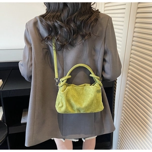 Détail du sac à main plissé en daim vert avocat avec poignée nouée et fine bandoulière