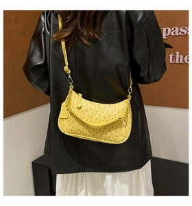 Dettaglio della borsa hobo gialla con texture in pelle di struzzo e catena dorata