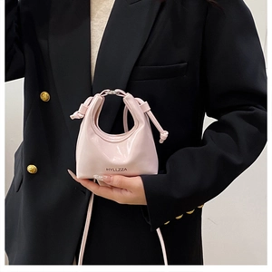 Dettaglio borsa a mezzaluna in pelle verniciata rosa con logo HYLLZZA e finiture argento