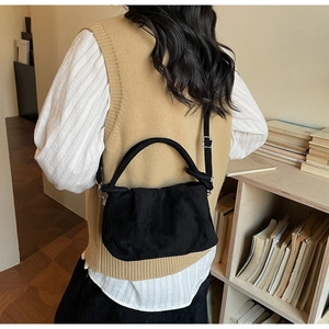 Mannequin portant un sac plissé noir avec bandoulière réglable et texture velours doux