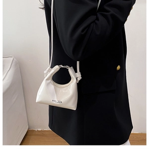 Dettaglio della mini borsa in vernice bianca con manico in metallo e logo nero inciso