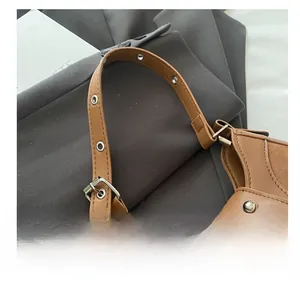 Close-up of brown leather bag strap with metal eyelets and branded JINGPIN embossing