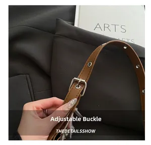 Detail of adjustable brown leather strap with silver metal buckle and metal eyelets