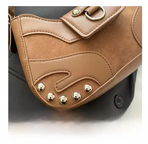 Detail of brown suede and smooth leather stitching with silver rivets on a vintage bag