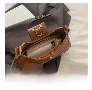 Internal view of the brown retro shoulder bag showing phone, lipstick and wallet storage