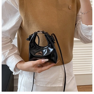 Dettaglio mini borsa in pelle verniciata nera con logo bianco e trama plissettata fine