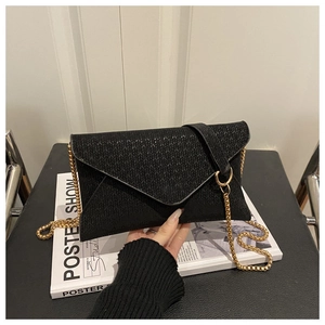 Close-up of black woven texture handbag with elegant gold chain strap and envelope flap