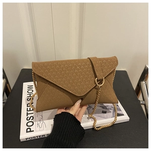 Detail of brown envelope clutch bag featuring textured V-weave pattern and gold chain