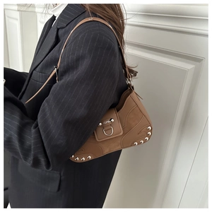 Close-up of vintage dark brown leather hobo bag with silver studs and adjustable strap