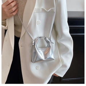 Dettaglio della mini borsa a tracolla argento metallizzato con logo e manico