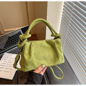 Détail du sac bandoulière plissé vert avec poignée nouée et boucle en métal argenté
