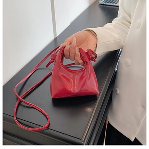 Dettaglio della mini borsa in vernice rossa con manico a nodo e tracolla staccabile