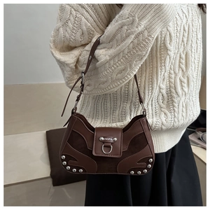 Close-up of brown vintage hobo bag featuring silver rivets and metal ring detail