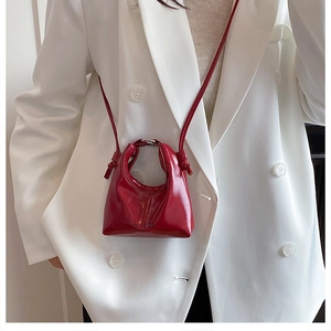 Dettaglio mini borsa a tracolla rossa in pelle verniciata con cinturino sottile