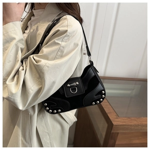 Detail showing vintage black motorcycle bag with silver rivets and metal ring buckle