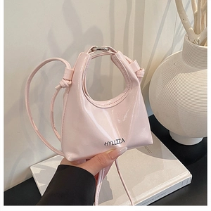 Dettaglio mini borsa in pelle verniciata rosa lucida con design geometrico e logo