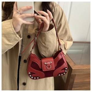 Detail of red vintage shoulder bag with silver rivets and mixed leather suede texture