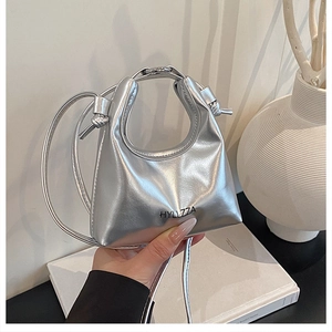 Dettaglio ravvicinato di una mini borsa a mano argento metallizzato con logo alla moda