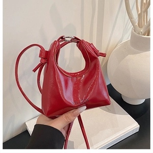 Dettaglio ravvicinato della borsa in vernice rossa lucida con elegante marchio HYLIZZA