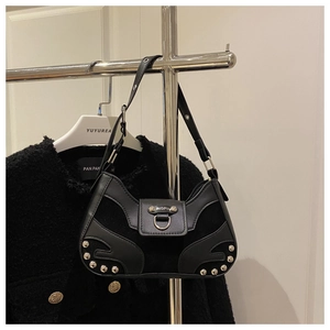 Detail of black leather and suede baguette bag with silver studs and D-ring buckle