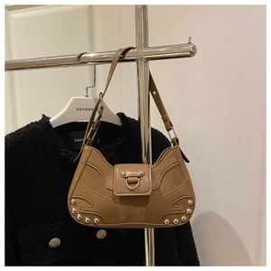 Close-up of khaki brown leather shoulder bag with silver rivets and metal ring detail