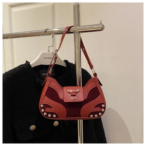 Close-up of red patchwork shoulder bag with silver rivet studs and U-shaped hardware