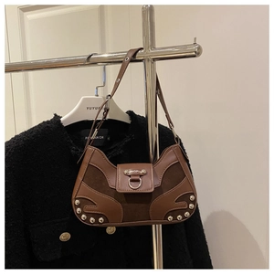 Detail of vintage brown leather handbag featuring metal rivets and textured patchwork