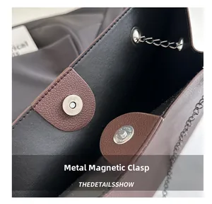 Dettaglio ravvicinato della chiusura magnetica in metallo e pelle della borsa marrone