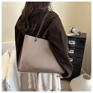 Dettaglio della borsa tote taupe con trama martellata e doppie tracolle a catena