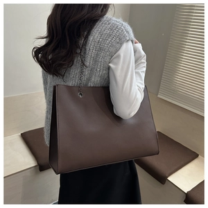 Vista laterale della borsa tote in pelle marrone scuro con tracolla a catena