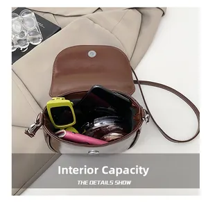 Internal capacity of the dark brown saddle bag showing space for phone and makeup