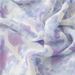 Detailed view of blue watercolor print on lightweight linen-feel fabric with tassels
