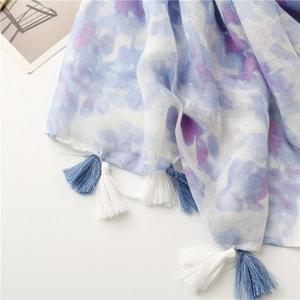 Close-up of elegant floral print scarf with soft tassels and artistic ink painting style