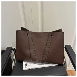 Dettaglio di una grande borsa tote caffè scuro con trama litchi e catena d'argento