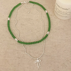 Collier double rang avec perles vert émeraude, chaîne argentée et pendentif nœud