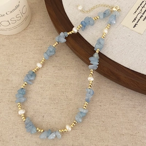 Handmade necklace featuring irregular blue stones, white pearls, and gold metal beads