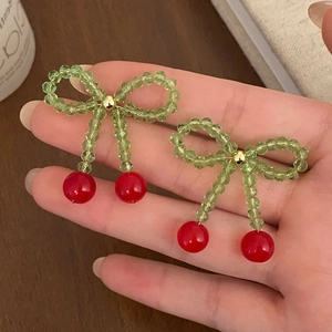 Handmade cherry earrings with red beads and green crystal bow on a stud post