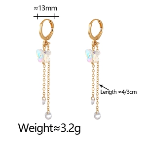 Gold butterfly tassel earrings with iridescent stones and long chains on white backdrop