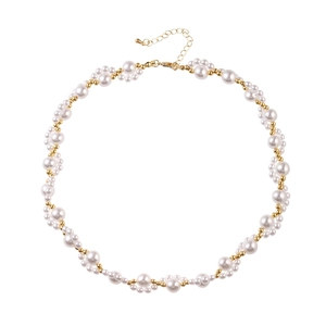 Elegant pearl necklace with alternating white pearls and golden beads in a wavy texture