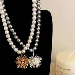 Eleganti collane di perle con ciondoli a stella in oro e argento su espositore