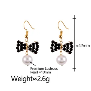 Boucles d'oreilles nœud noir perles blanches 10mm et crochets dorés sur fond blanc pur