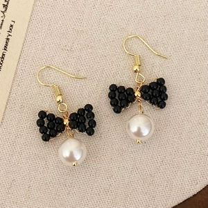Boucles d'oreilles nœud en perles noires avec pampilles blanches et crochets dorés