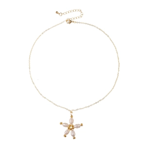 Collier doré avec pendentif tournesol en perles d'eau douce sur fond blanc neutre