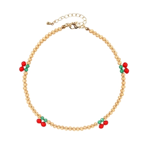 Détail du collier de perles en cristal avec motifs cerises et finitions dorées
