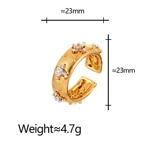 Macro view of brushed gold ring showing 23mm diameter measurement and star-set zircons