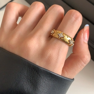 Detailed view of vintage gold ring with zircon clover pattern on a model's hand