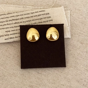 Orecchini a goccia d'oro minimalisti con finitura lucida a specchio su tessuto vintage