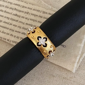 Macro view of gold brushed wide band ring with sparkling star-set zirconias